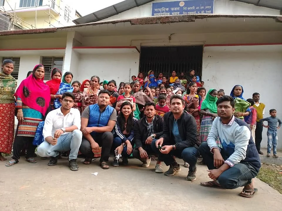 NANF volunteers with village women outside a community hall in Assam after an outreach programme